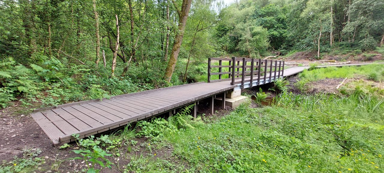 the start of a boardwalk in the countryside, across marsh wetlands