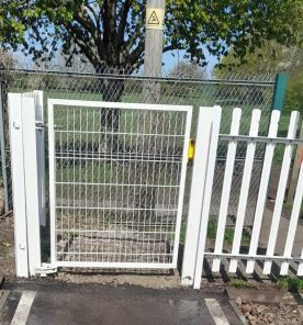 White steel pedestrian gate for use at a rail crossing