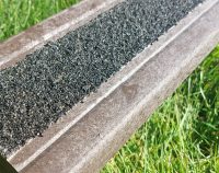 A recycled plastic decking board with tough anti-slip surface