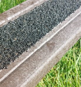 A recycled plastic decking board with tough anti-slip surface