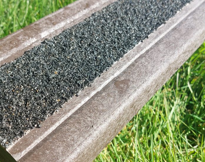 A recycled plastic decking board with tough anti-slip surface
