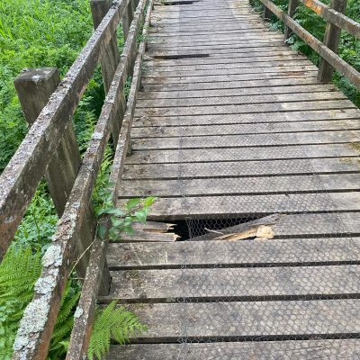 an unsafe, decaying timber deck board surface