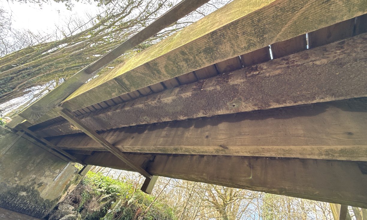 a decaying timber bridge beam needing replacement