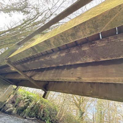 a decaying timber bridge beam needing replacement